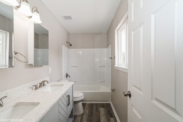 full bathroom featuring bathtub / shower combination, a sink, toilet, and wood finished floors