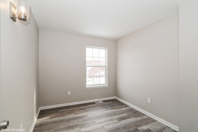 unfurnished room featuring baseboards and wood finished floors