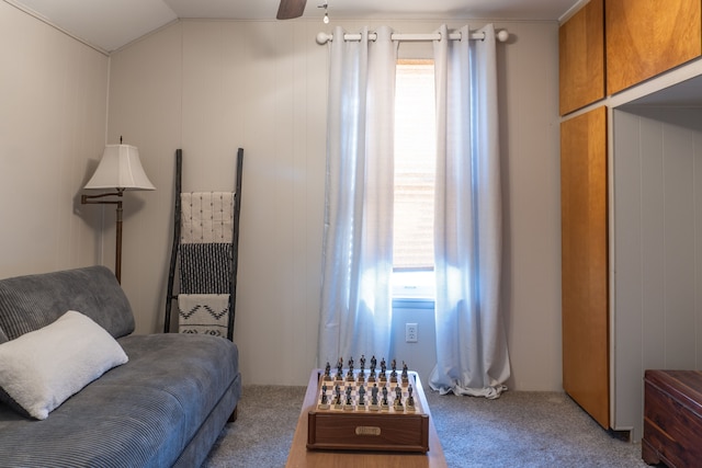 living area with vaulted ceiling, ceiling fan, plenty of natural light, and carpet