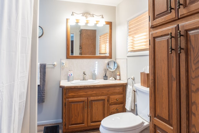 bathroom featuring toilet, visible vents, decorative backsplash, and vanity