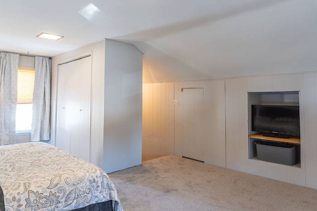 carpeted bedroom featuring vaulted ceiling and a closet