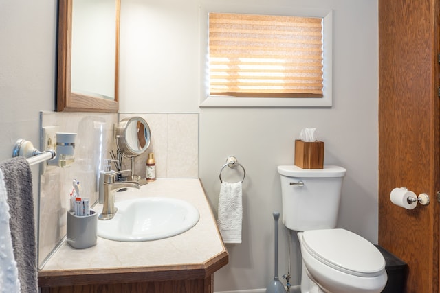 bathroom featuring backsplash, toilet, and vanity