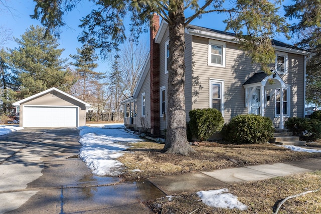 view of side of property with a garage, an outbuilding, and a chimney