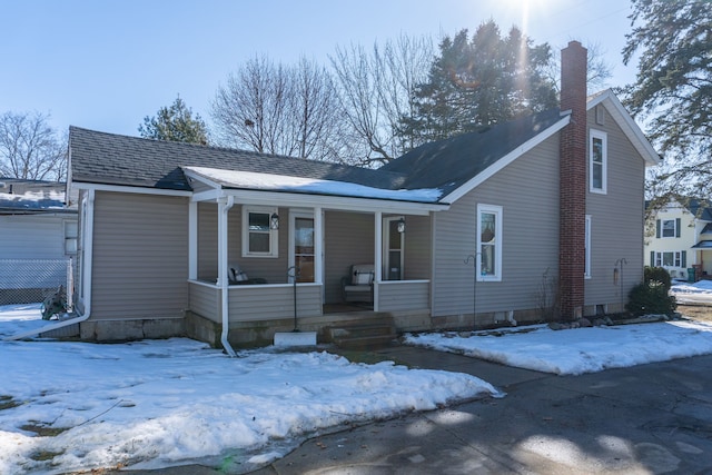 view of front facade with a porch and a chimney