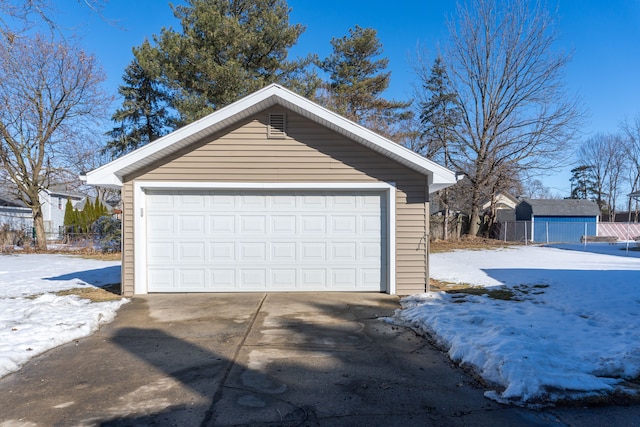 snow covered garage with a detached garage