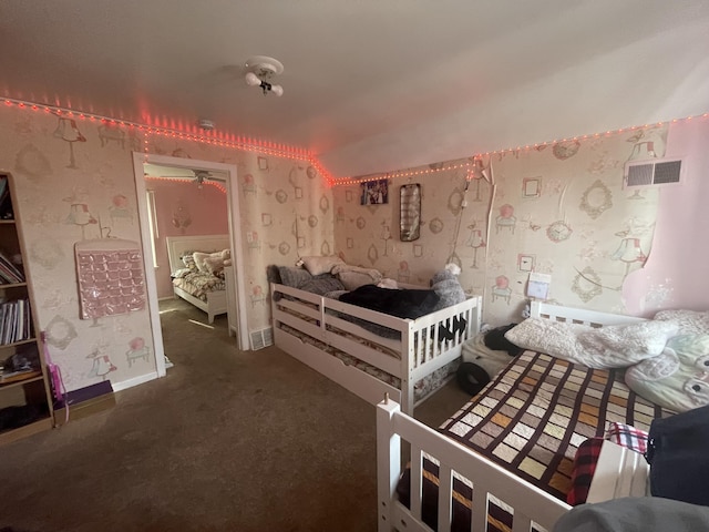 unfurnished bedroom with dark colored carpet, visible vents, and wallpapered walls