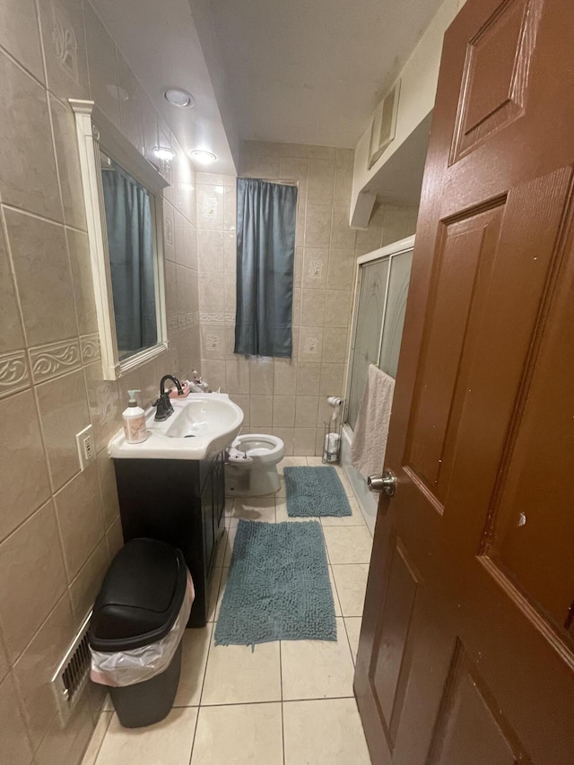 full bathroom featuring visible vents, toilet, tile patterned floors, a shower stall, and tile walls