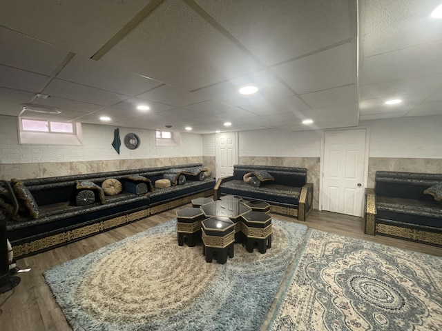 living room with a wainscoted wall, dark wood finished floors, and a paneled ceiling