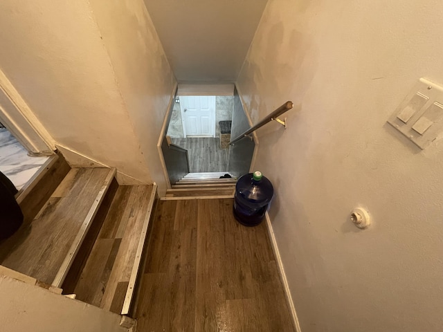 stairway with baseboards and wood finished floors