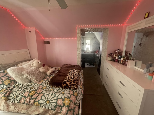 bedroom with a ceiling fan, dark carpet, visible vents, and vaulted ceiling