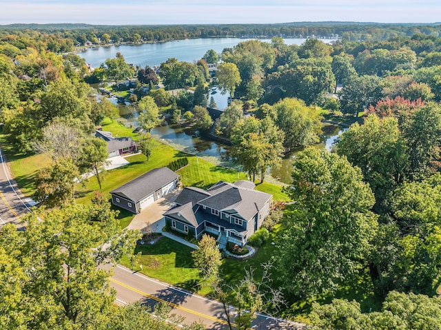 birds eye view of property featuring a water view and a wooded view