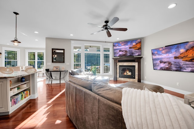 living room with baseboards, a glass covered fireplace, dark wood-style floors, ceiling fan, and recessed lighting