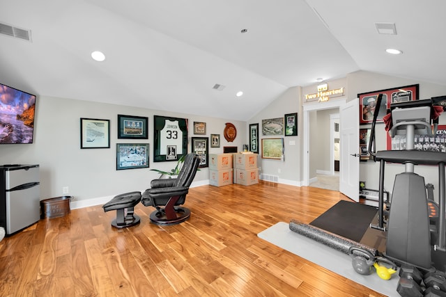 exercise area featuring lofted ceiling, light wood-type flooring, and visible vents