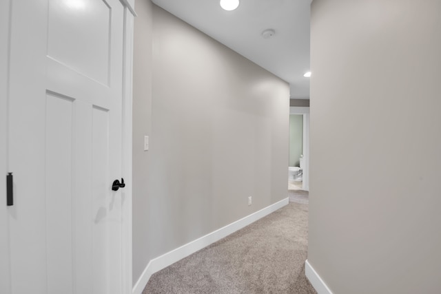 hallway featuring light carpet, recessed lighting, and baseboards