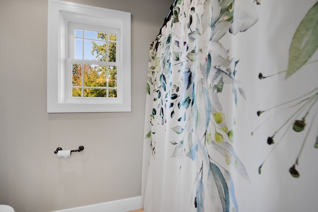 full bath with baseboards and a shower with shower curtain