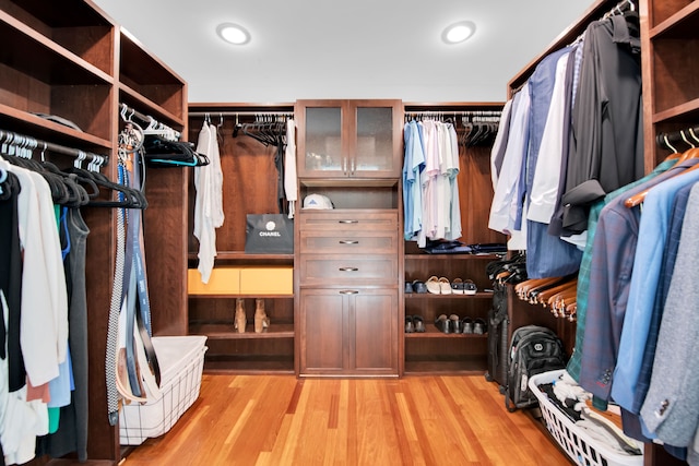 walk in closet with light wood-style floors