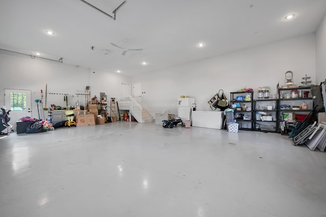 garage featuring a workshop area, freestanding refrigerator, and recessed lighting