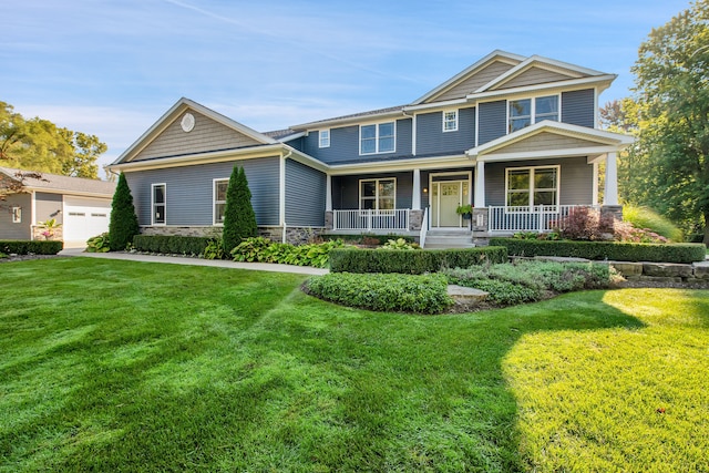 craftsman-style home featuring stone siding, a front yard, and covered porch