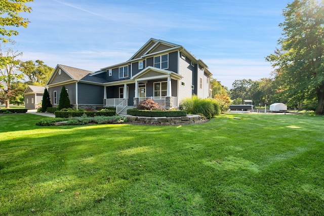 view of front of home with a porch, stone siding, and a front lawn