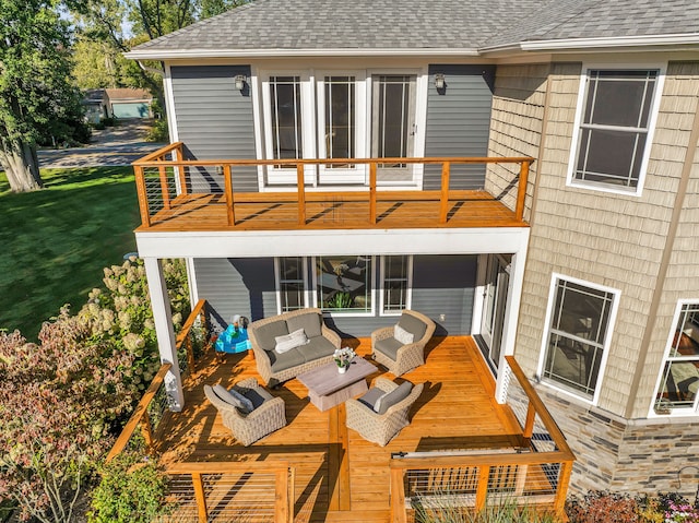 rear view of house with a balcony, a shingled roof, outdoor lounge area, stone siding, and a wooden deck