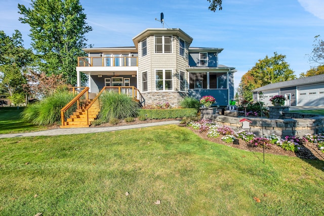 rear view of property featuring a balcony, stone siding, stairs, and a yard