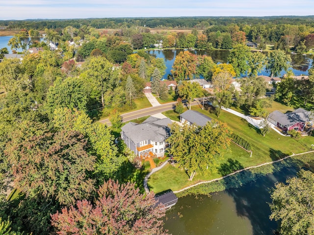 drone / aerial view with a forest view and a water view