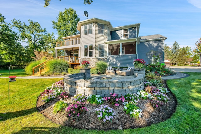 back of property featuring a yard, stairway, and a balcony