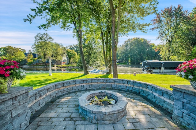 view of patio / terrace featuring a water view and a fire pit