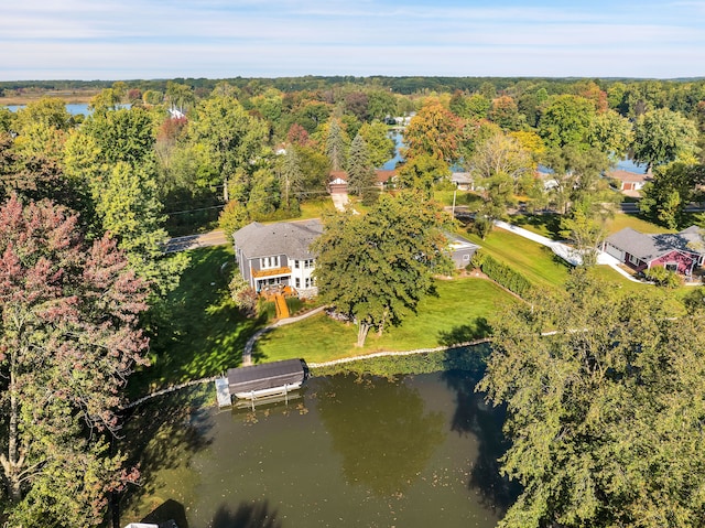 birds eye view of property featuring a water view and a wooded view