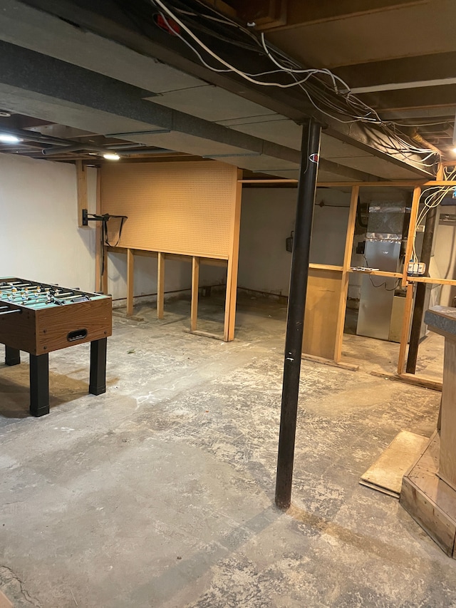 unfinished basement featuring heating unit