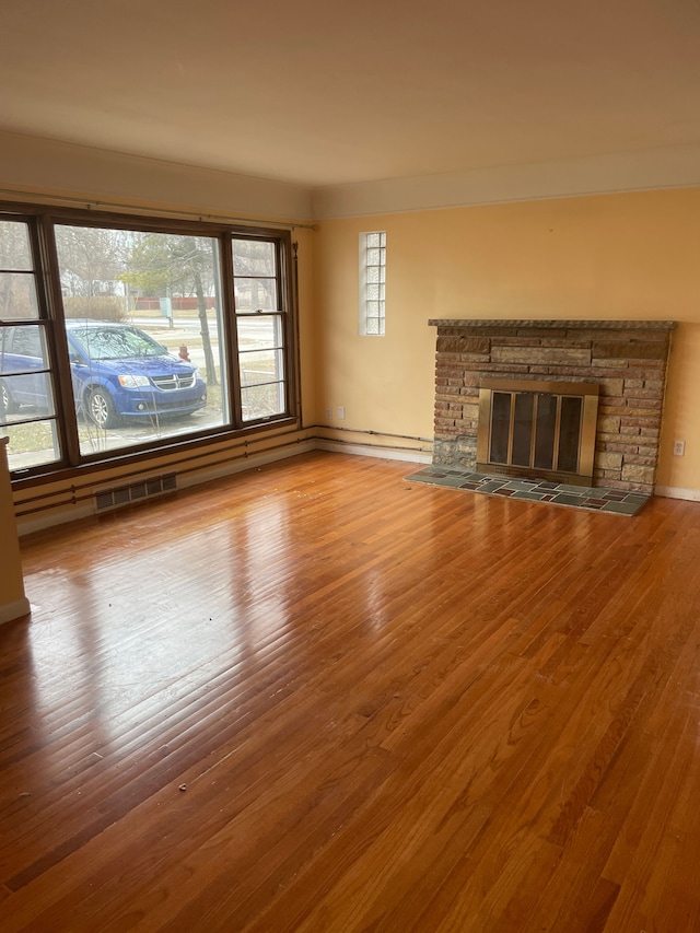 unfurnished living room featuring a fireplace and wood finished floors