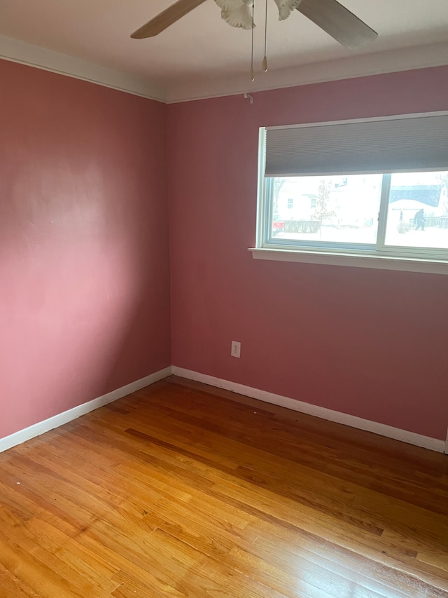 empty room featuring light wood-style floors, baseboards, and a ceiling fan