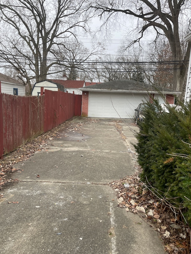 view of property exterior with a garage, fence, an outdoor structure, and brick siding