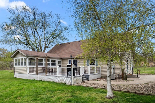 8770 W E Rd, Lakeside, MI 49128 - back of house featuring a lawn, a deck, a sunroom, and roof with shingles