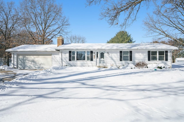 view of front of home with an attached garage, driveway, and a chimney