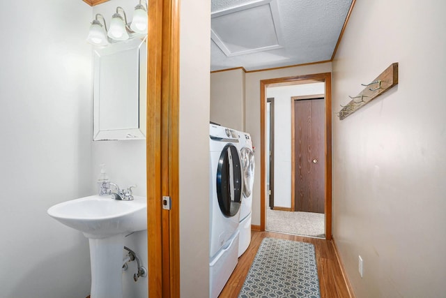 washroom with washer / clothes dryer, attic access, a sink, light wood-type flooring, and laundry area