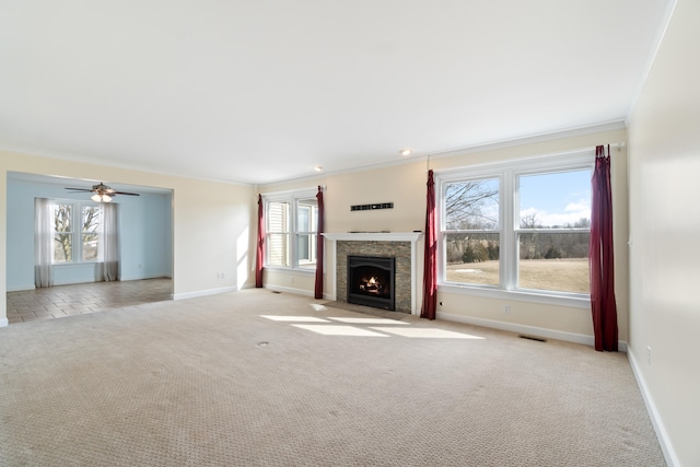 unfurnished living room with light colored carpet, visible vents, a fireplace with flush hearth, ornamental molding, and baseboards