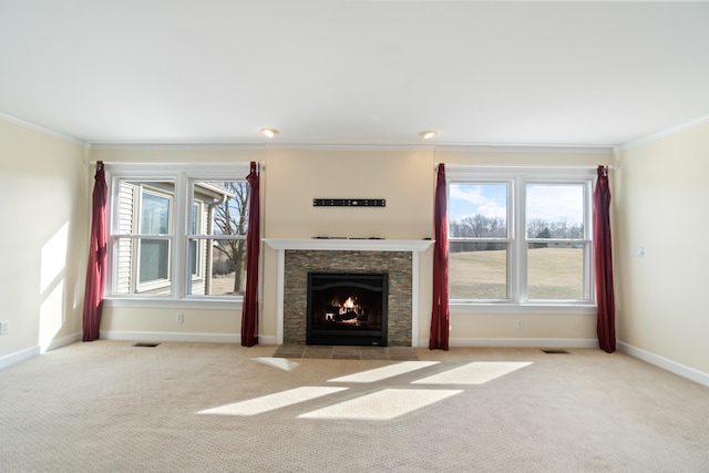 unfurnished living room featuring carpet floors, visible vents, ornamental molding, a stone fireplace, and baseboards