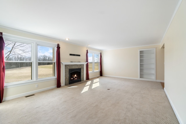 unfurnished living room with light carpet, a fireplace with flush hearth, visible vents, baseboards, and ornamental molding