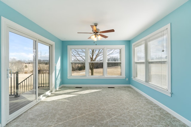 unfurnished sunroom with a ceiling fan