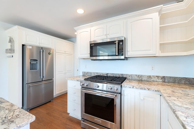 kitchen featuring light stone counters, stainless steel appliances, recessed lighting, white cabinets, and wood finished floors