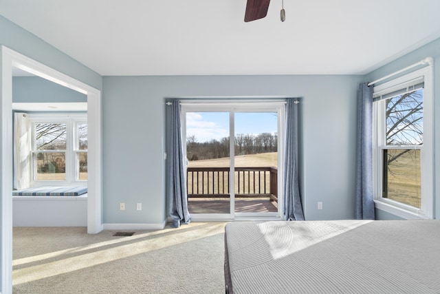 unfurnished bedroom featuring carpet, access to outside, multiple windows, and visible vents