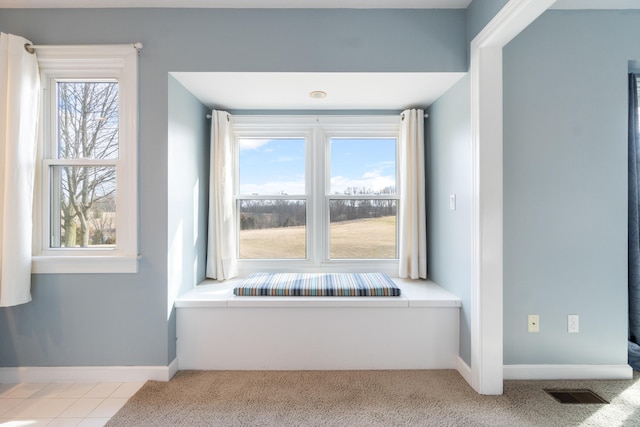 interior space with carpet, baseboards, and visible vents