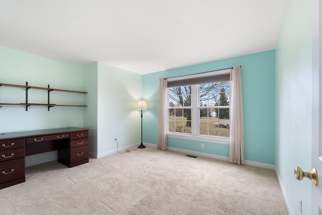 unfurnished office featuring visible vents, light carpet, and baseboards