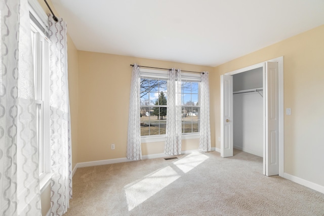 unfurnished bedroom with carpet, visible vents, baseboards, and a closet