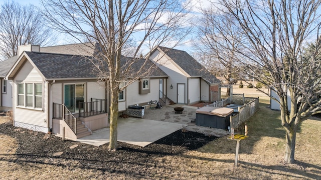 back of house featuring entry steps, a shingled roof, fence, a chimney, and a patio area