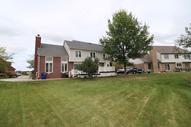 back of house with brick siding, a lawn, and a chimney