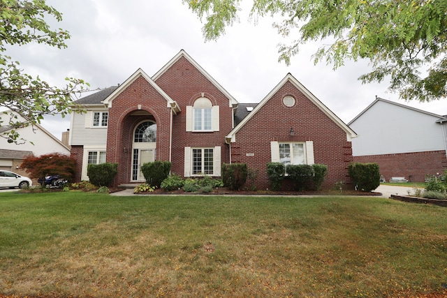 view of front of house with a front yard and brick siding