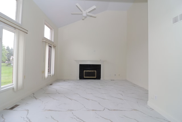 unfurnished living room with marble finish floor, visible vents, a premium fireplace, ceiling fan, and high vaulted ceiling