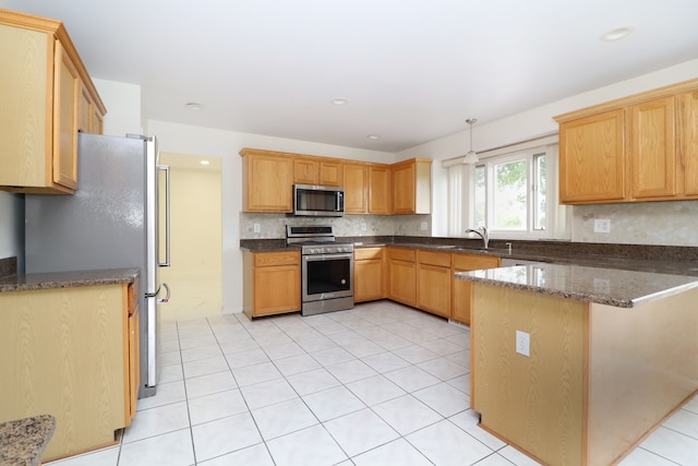 kitchen featuring stainless steel appliances, tasteful backsplash, hanging light fixtures, a sink, and a peninsula